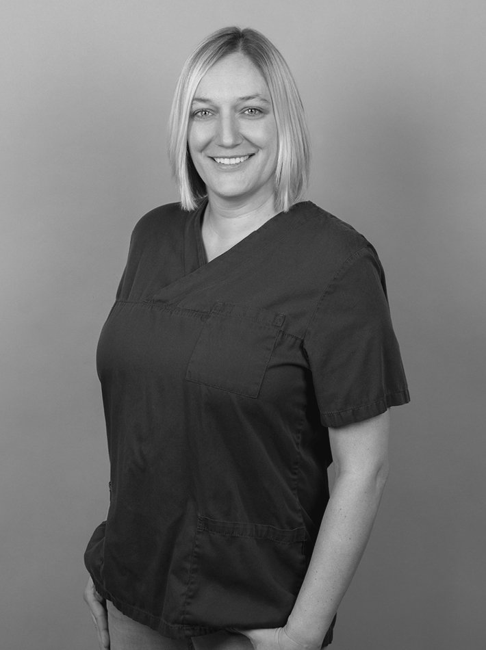 Frau mit kurzen blonden Haaren und blauen Arbeitsklamotten