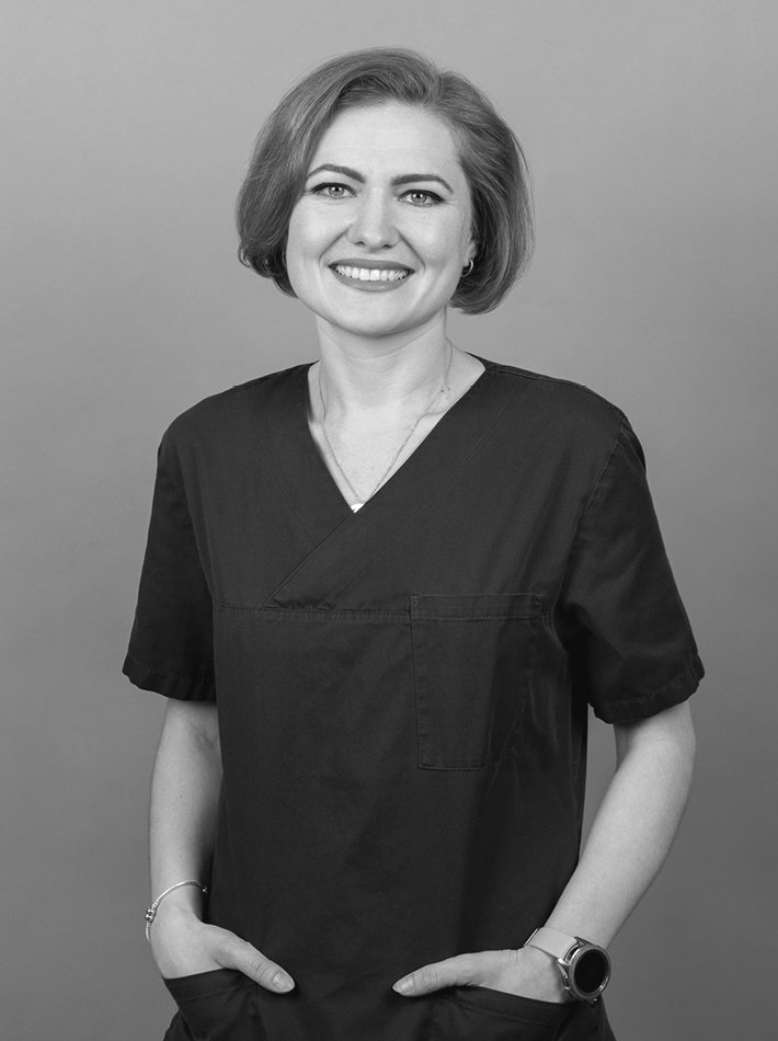 Frau mit kurzen braunen Haaren und blauen Arbeitsklamotten